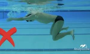 A swimmer demonstrates an incorrect breaststroke kick, with knees splayed outwards. A red X marks the error.