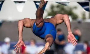 A swimmer in mid-air, showcasing the powerful back muscles developed through dedicated back exercises.