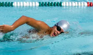 Swimmer in a pool, focused on endurance workouts, powering through the water with determined strokes.