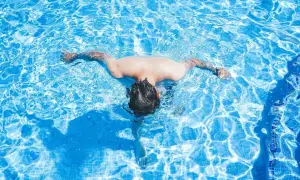 A person swims in a bright blue pool. Wondering how often should I swim? This refreshing activity is great for fitness.