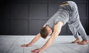 Man in downward-facing dog pose, a key stretch for yoga for triathletes, improving flexibility and recovery.