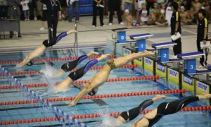 Swimmers dive into the pool for mid-distance swim workouts.