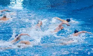 Intense water polo periods with athletes battling for the ball amidst splashing water.