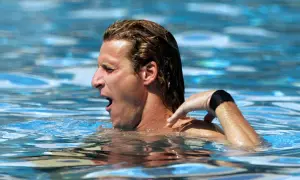 A swimmer gasps for air, his arm reaching back. The resistance of the water explains why does the pool make you tired.