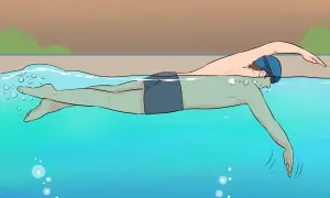 A person in swim cap and goggles practices freestyle swimming, a common stroke for beginner swim lessons for adults.