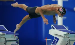 Michael Phelps dives into the water, his body streamlined. His focused expression hints at the intense effort and controlled michael phelps heart rate required for peak performance.