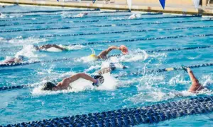 Swimmers push through the water in a competitive race, showcasing an intense hiit swim workout.
