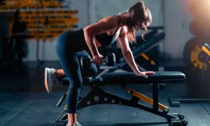 Woman performing a dumbbell row as part of her triathlon strength training plan.