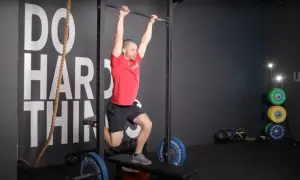 Man performing a hanging exercise, possibly part of butterfly sets, in a gym.