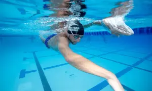 Underwater view of a swimmer performing a catch up swim drill, focusing on technique and efficiency in the pool.