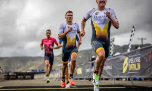 Triathletes race, pushing their limits. The lead runner's determined face hints at the grueling Ironman triathlon distances ahead.