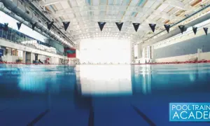An empty indoor swimming pool with black Speedo flags. While chlorine kills many germs, does chlorine kill COVID?