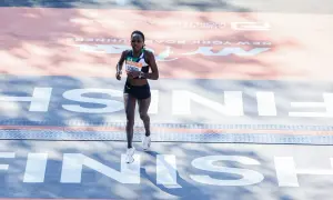 Runner crosses the finish line in her Under Armour tri suit, a testament to her endurance and dedication.