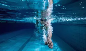 Underwater view of a swimmer pushing through the water, a powerful stroke for endurance swim workouts.
