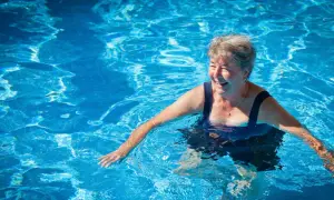 Smiling woman enjoys a refreshing swim, proving you can swim with a pacemaker and live life to the fullest.
