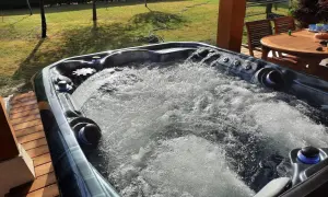 Bubbling hot tub on a sunny deck. Wondering how long after a tattoo can you go in a hot tub? This one looks inviting!