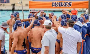 Waterpolo development: A team huddles, fists raised, showing unity and focus before a game.