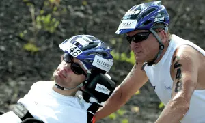 Dick Hoyt and his son Rick, a participant in the Ironman, wearing helmets and sunglasses. Rick has the number 48 on his helmet.