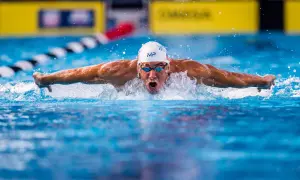 Michael Phelps powers through the water, his arms extended in a butterfly stroke, as if he could fly.