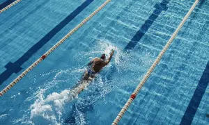 Swimmer powering through a lane, a great way to see how many calories do you burn in the pool.