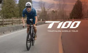 A determined athlete cycles on a road, preparing for the T100 Triathlon World Tour.