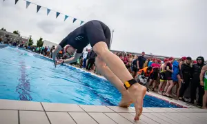 A swimmer poised to dive, embodying the motivation for swimmers to push their limits and embrace the challenge.