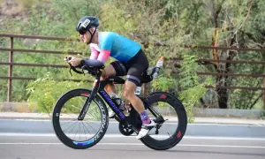 Athlete in aerodynamic position on a triathlon bike, training for a race.
