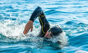 Athlete in wetsuit swims powerfully, a testament to the journey from couch to triathlon.