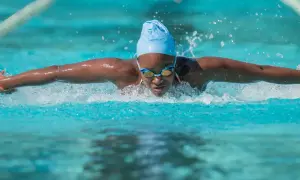 A swimmer powers through the water, a blur of motion and spray. This intense workout is a great way to burn swim calories.