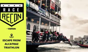 Athletes dive from a boat into the water for the Escape from Alcatraz Triathlon.