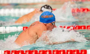 Ryan Lochte, wearing a blue "Florida" cap, powers through the water during intense swim workouts.