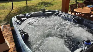 Bubbling hot tub on a sunny deck. Wondering how long after a tattoo can you go in a hot tub? This one looks inviting!