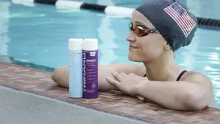 Swimmer with an American flag cap and goggles rests by the pool, with TRIHARD swimmer's shampoo bottles nearby, offering a solution on how to protect skin from chlorine.
