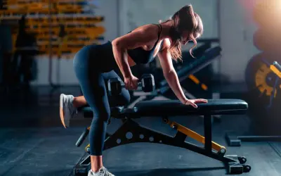 Woman performing a dumbbell row as part of her triathlon strength training plan.