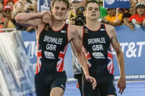 The Brownlee brothers, Alistair and Jonny, in their Great Britain triathlon kits, exhausted but together after a race.