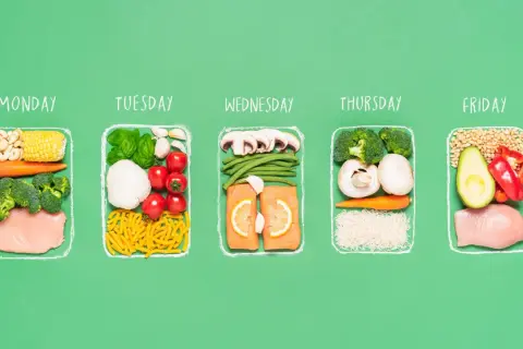 A week's worth of healthy meals for a half ironman nutrition plan, featuring chicken, salmon, vegetables, and grains for each day.