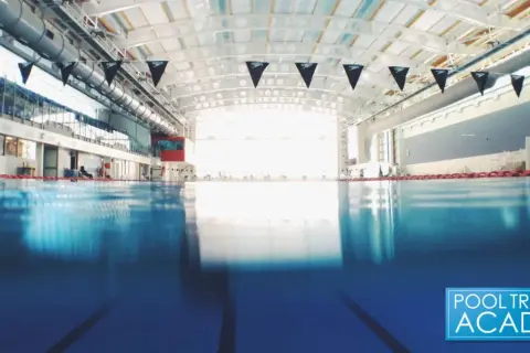 An empty indoor swimming pool with black Speedo flags. While chlorine kills many germs, does chlorine kill COVID?