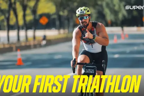A smiling man on a bike gives a shaka sign, ready for his first triathlon. He's a perfect example of triathlon newbies embracing the challenge.