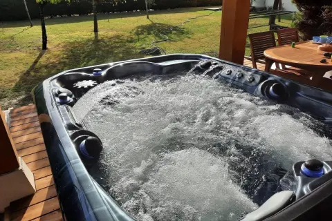Bubbling hot tub on a sunny deck. Wondering how long after a tattoo can you go in a hot tub? This one looks inviting!