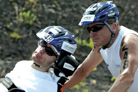 Dick Hoyt and his son Rick, a participant in the Ironman, wearing helmets and sunglasses. Rick has the number 48 on his helmet.