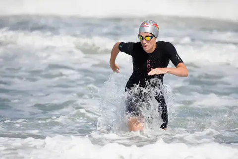 Lucy Charles Barclay emerges from the ocean, a powerful stride through the waves.