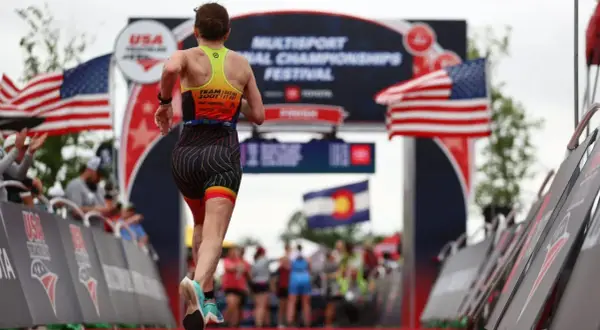 A triathlete runs towards the finish line at the USA Triathlon Multisport National Championships Festival, a testament to their USA Triathlon membership.