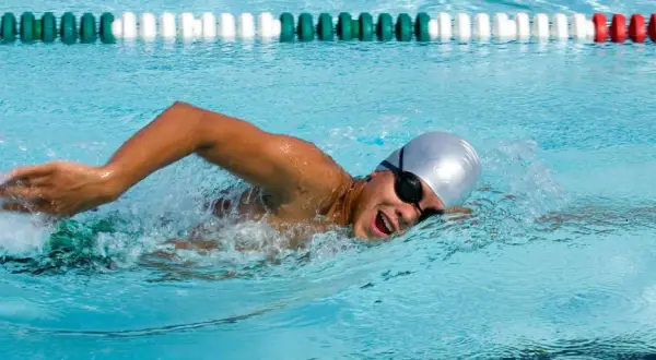 Swimmer in a pool, focused on endurance workouts, powering through the water with determined strokes.