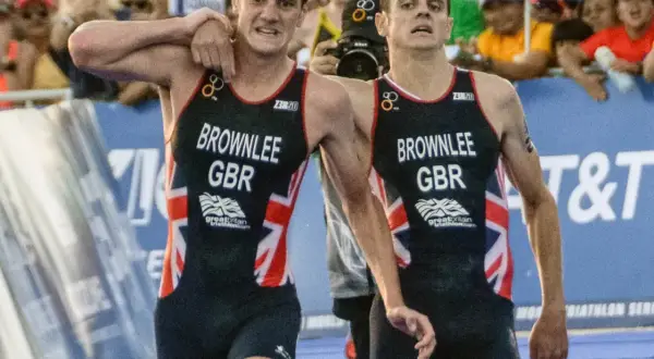 The Brownlee brothers, Alistair and Jonny, in their Great Britain triathlon kits, exhausted but together after a race.