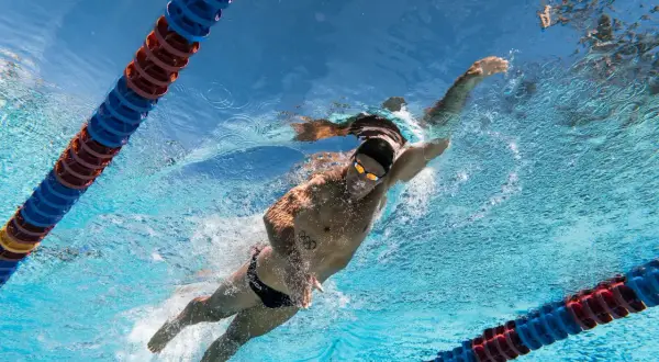 Underwater view of a swimmer performing the backstroke, with lane lines visible. Learn backstroke tips from this powerful stroke.