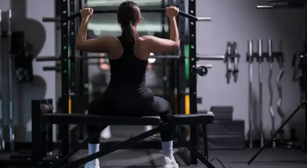 Woman performing lat pulldowns, a key exercise for weight training for triathlon, building upper body strength for swimming and cycling.