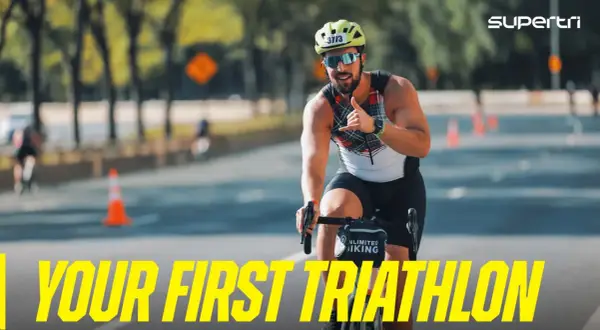 A smiling man on a bike gives a shaka sign, ready for his first triathlon. He's a perfect example of triathlon newbies embracing the challenge.