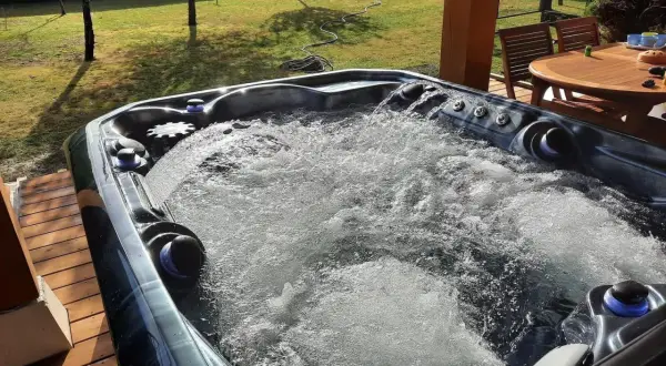 Bubbling hot tub on a sunny deck. Wondering how long after a tattoo can you go in a hot tub? This one looks inviting!