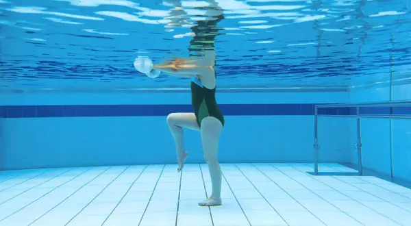 Underwater view of a person doing aquatic exercise with weights, showcasing the running in water benefits for a low-impact workout.