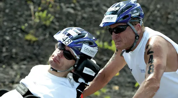 Dick Hoyt and his son Rick, a participant in the Ironman, wearing helmets and sunglasses. Rick has the number 48 on his helmet.